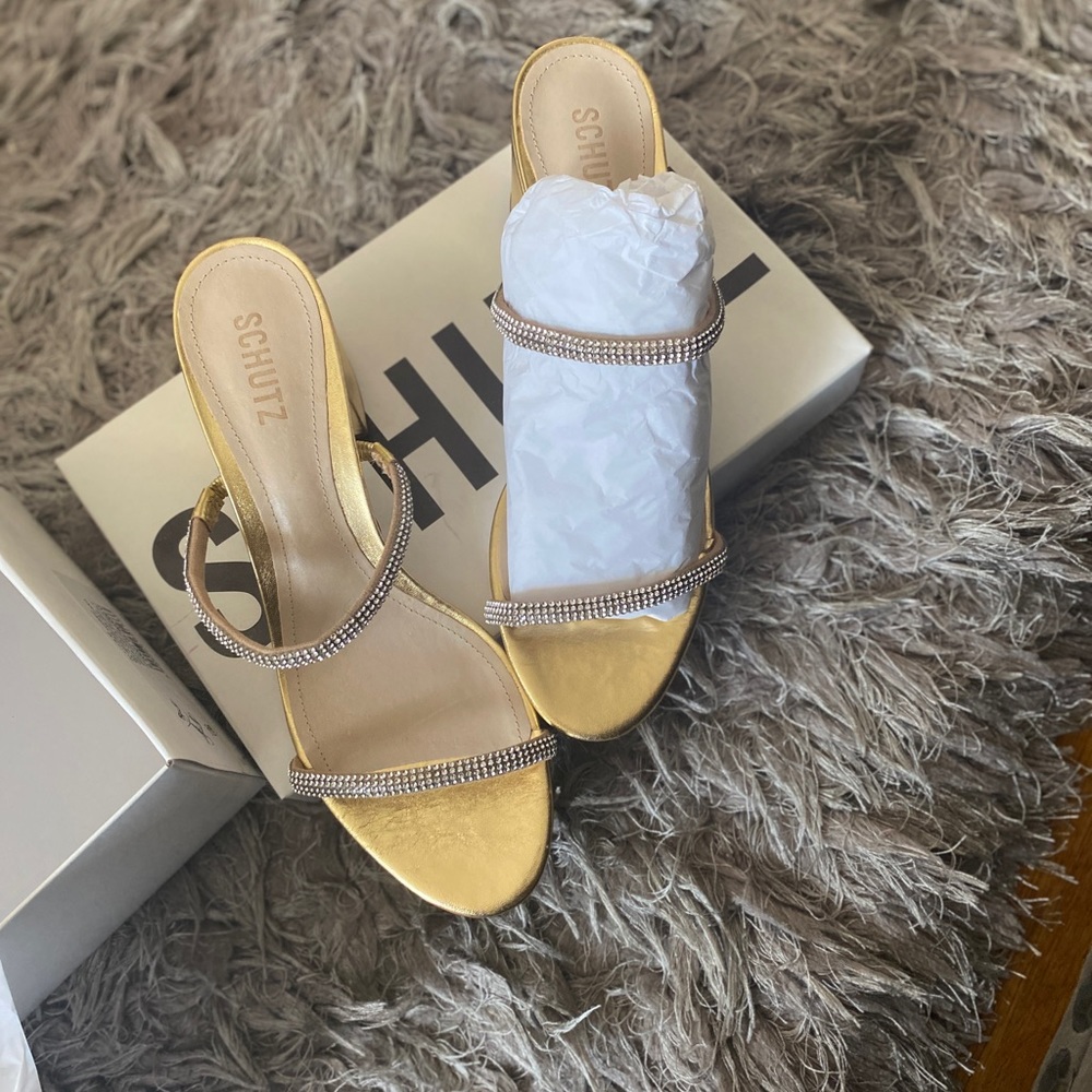 The Ully Lo mules Schutz metallic faux leather with crystal-embellished straps.